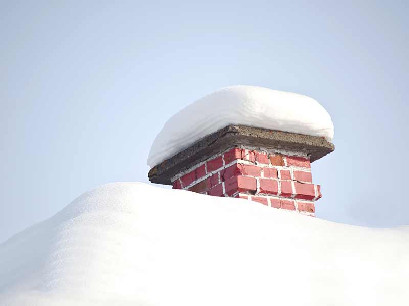 Snow sitting on top of chimney that requires removal in Ottawa