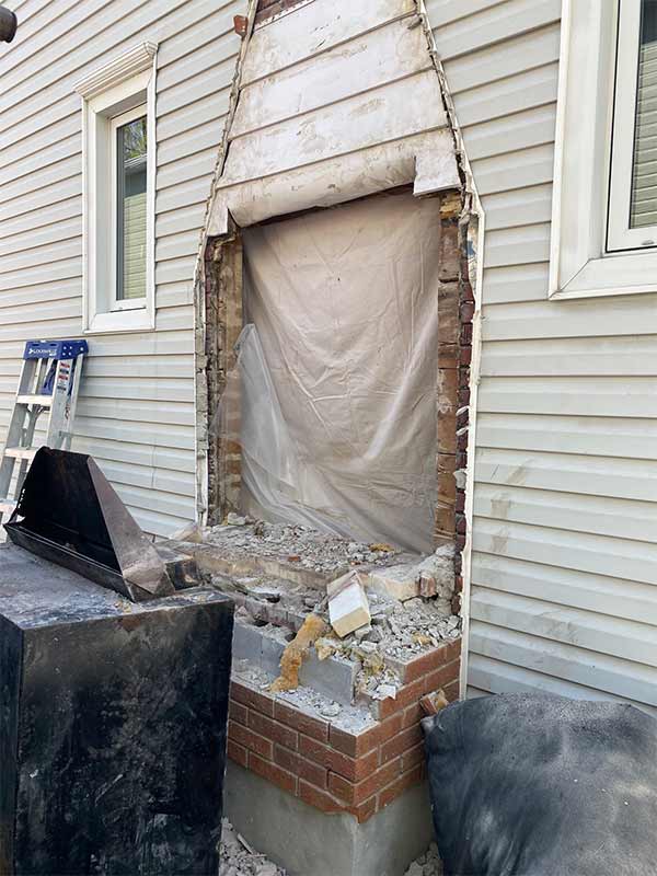 Hole in siding from chimney removal requiring repair