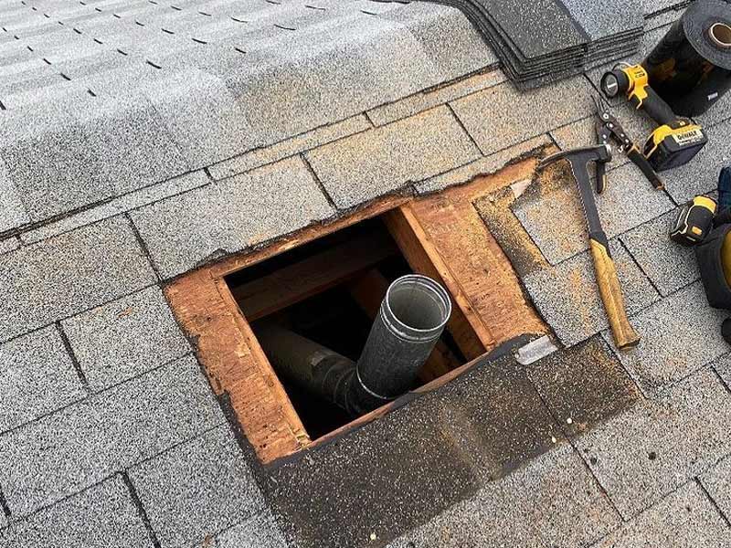 Hole opened in roof during chimney removal requiring shingle and flashing repair